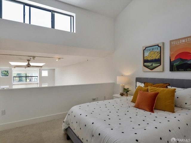 carpeted bedroom featuring a high ceiling