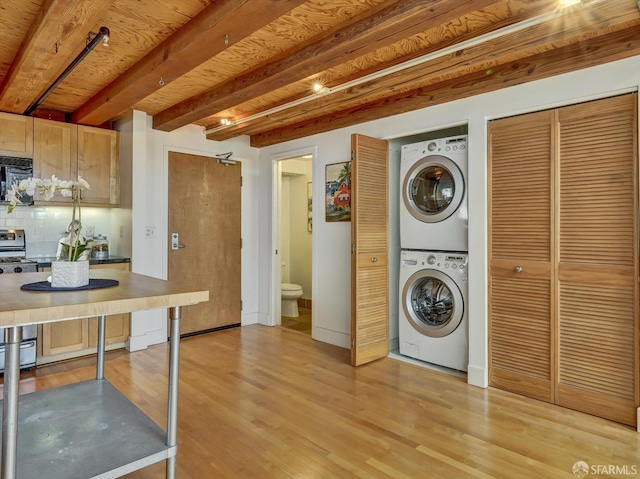 clothes washing area featuring light hardwood / wood-style floors and stacked washer and dryer