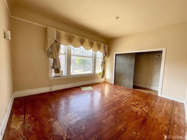 unfurnished bedroom featuring wood-type flooring and a closet