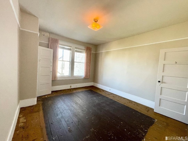 spare room featuring dark wood-type flooring