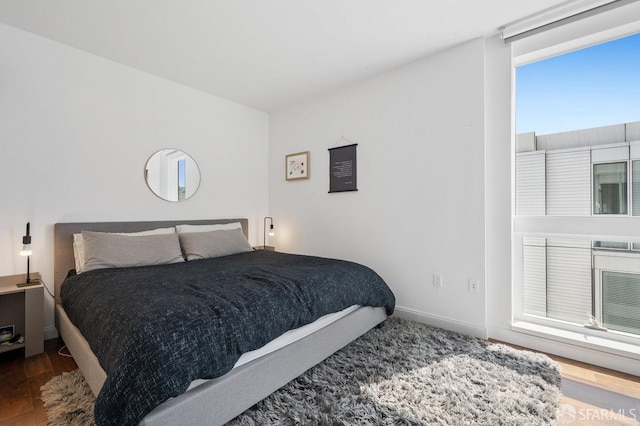 bedroom featuring baseboards and wood finished floors