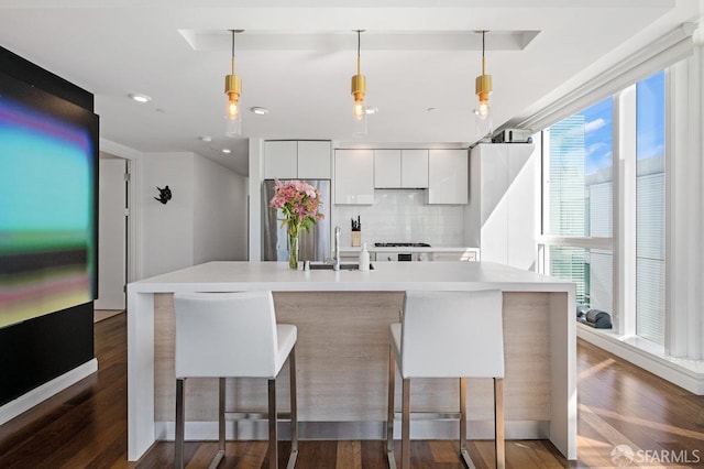 kitchen with modern cabinets, white cabinetry, light countertops, and wood finished floors