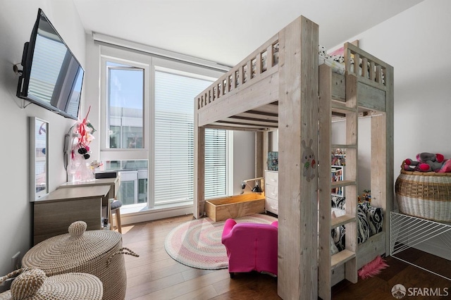 bedroom with multiple windows and wood finished floors