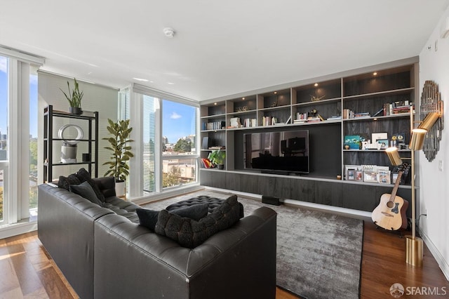 living room featuring built in features, a wall of windows, and wood finished floors