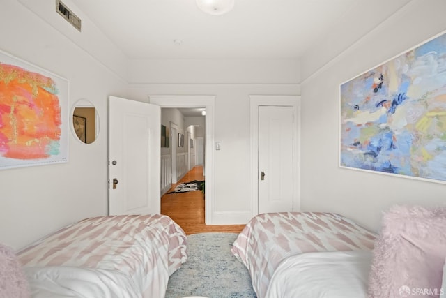 bedroom featuring wood finished floors and visible vents