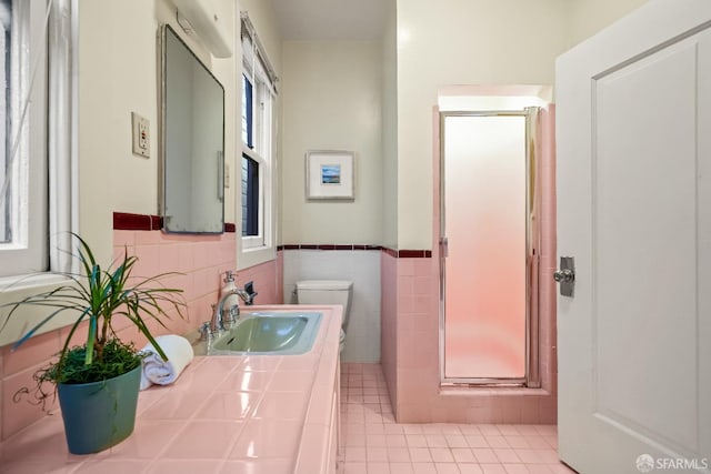 bathroom with vanity, a shower stall, toilet, and tile walls