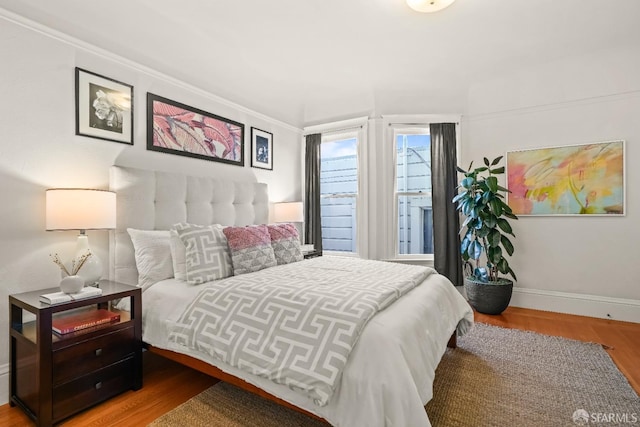 bedroom featuring baseboards and wood finished floors