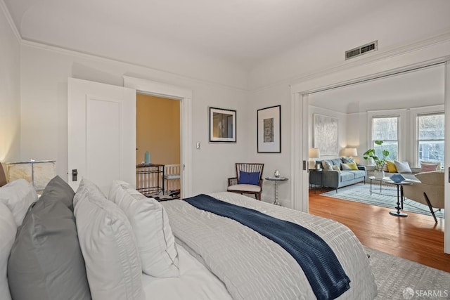 bedroom with visible vents and wood finished floors