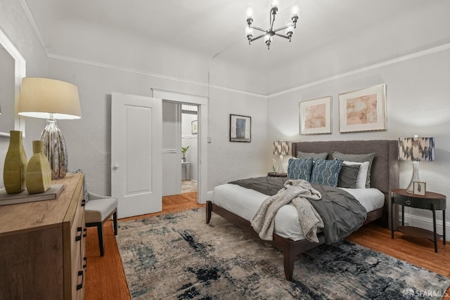 bedroom featuring an inviting chandelier and wood finished floors