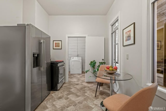 kitchen featuring washer / dryer, stone finish floor, range with gas stovetop, and high quality fridge