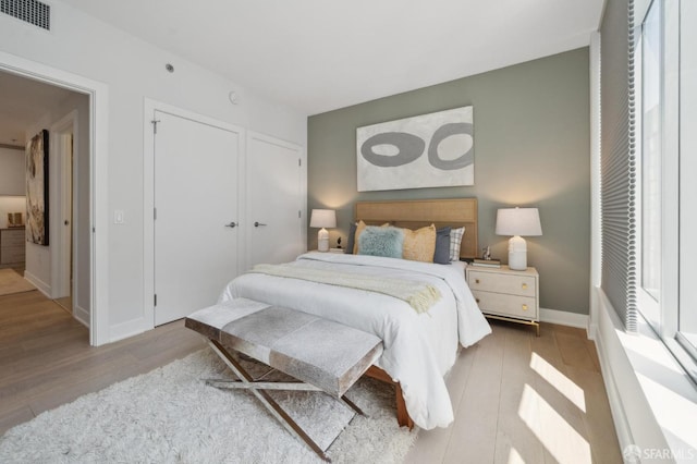 333 Beale St Unit 7G, San Francisco, CA 94105 - bedroom featuring visible vents, baseboards, wood finished floors, and a closet