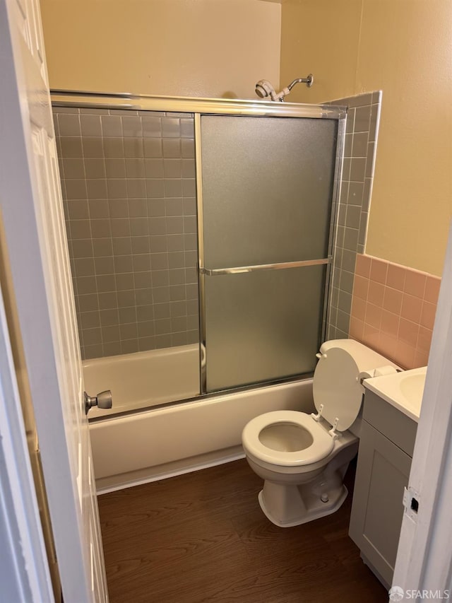130 Albatross Ct Unit 16, San Francisco, CA 94124 - bathroom featuring vanity, wood finished floors, toilet, shower / bath combination with glass door, and tile walls