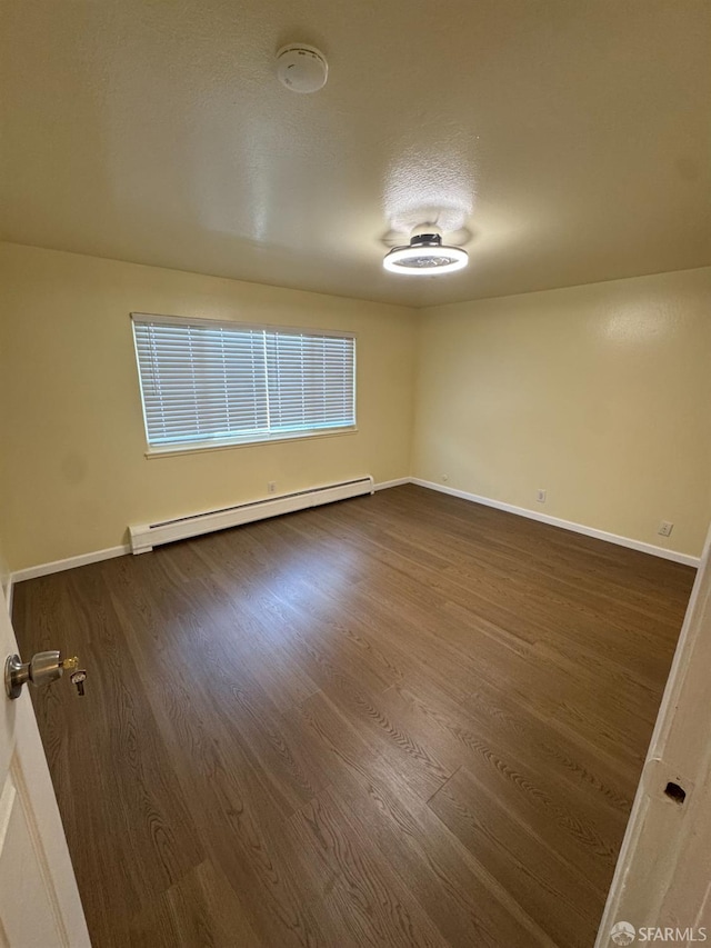 130 Albatross Ct Unit 16, San Francisco, CA 94124 - unfurnished room with a baseboard heating unit, dark wood-style floors, baseboards, and a smoke detector