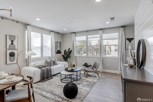 living room featuring baseboards, visible vents, and recessed lighting