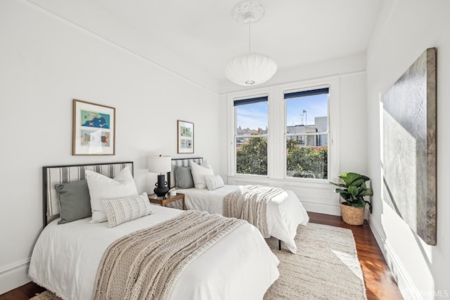 bedroom with baseboards and dark wood-style flooring