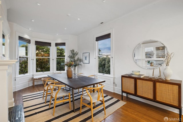 dining area with dark wood-type flooring, breakfast area, crown molding, and recessed lighting