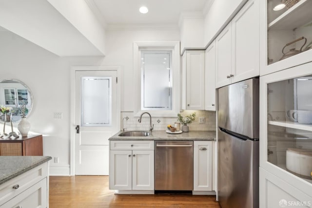 kitchen featuring light stone countertops, white cabinetry, appliances with stainless steel finishes, and a sink