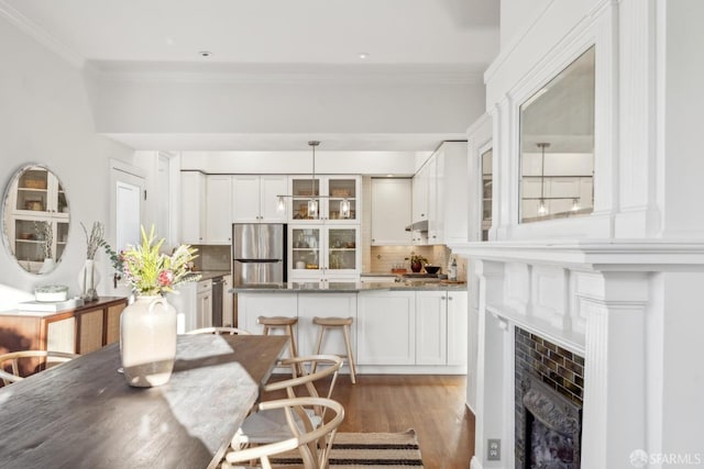 dining space featuring ornamental molding and dark wood finished floors