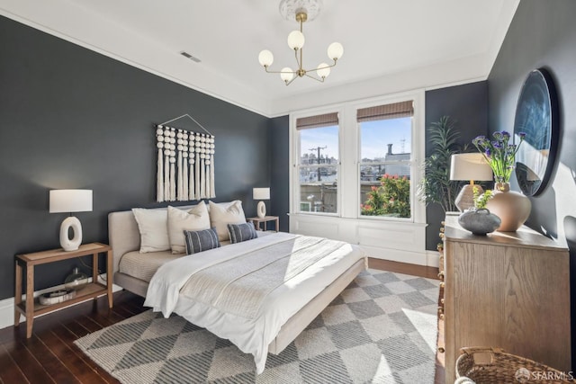 bedroom featuring dark wood-style floors, baseboards, visible vents, and a chandelier