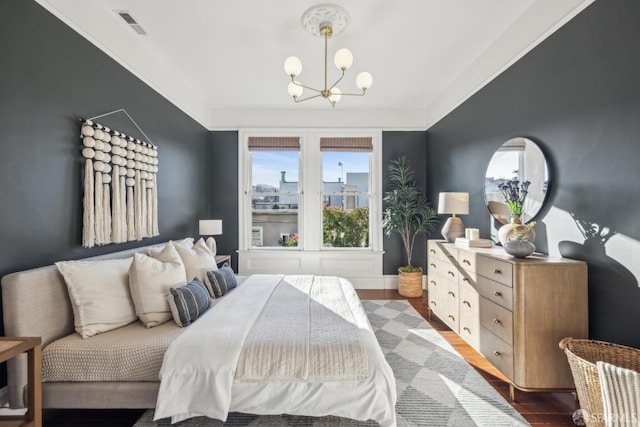 bedroom with dark wood-style flooring, crown molding, a notable chandelier, visible vents, and baseboards