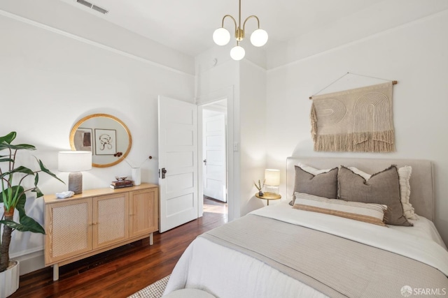 bedroom featuring dark wood-style floors, visible vents, and an inviting chandelier