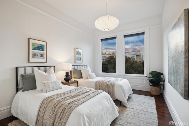 bedroom with dark wood finished floors and baseboards