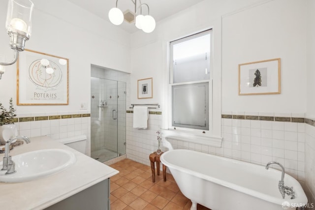 bathroom with vanity, tile walls, a freestanding bath, tile patterned floors, and a stall shower