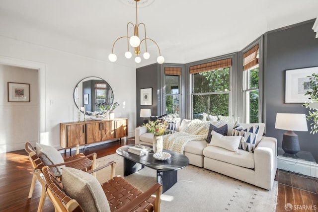 living area featuring baseboards, dark wood finished floors, and a notable chandelier