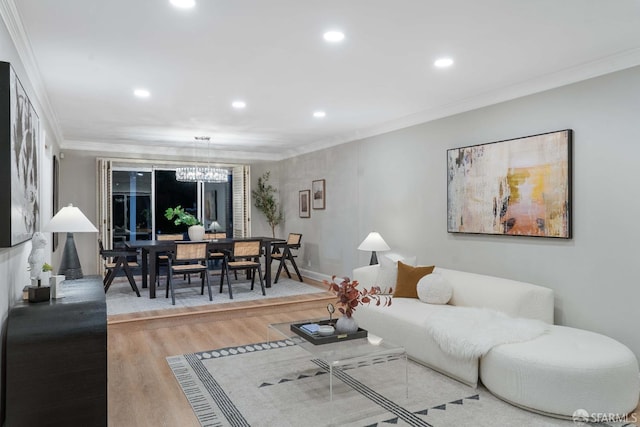 living room featuring hardwood / wood-style flooring, an inviting chandelier, and ornamental molding