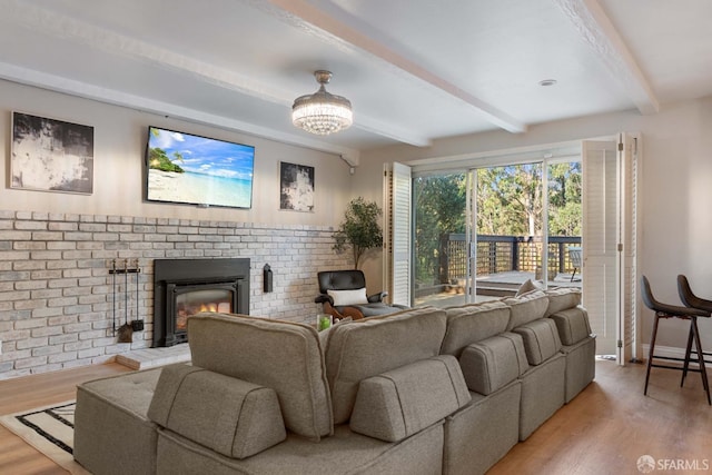 living room featuring a fireplace, beam ceiling, and light wood-type flooring