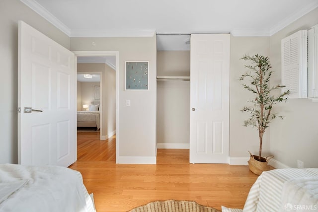 bedroom featuring a closet, hardwood / wood-style flooring, and ornamental molding