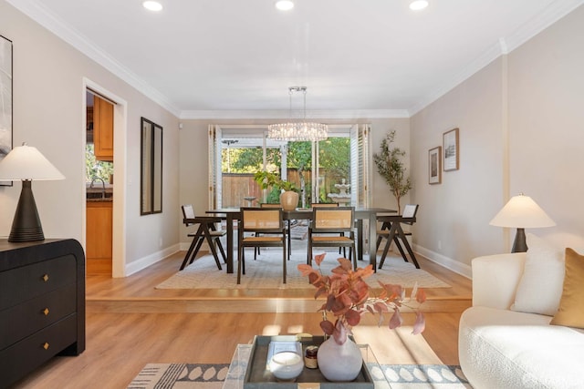 living room with light wood-type flooring, ornamental molding, a notable chandelier, and sink