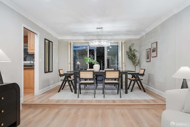 dining room featuring light hardwood / wood-style flooring, crown molding, and a notable chandelier