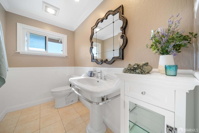 bathroom with crown molding, toilet, and tile patterned flooring