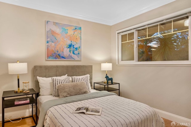 bedroom featuring hardwood / wood-style flooring and ornamental molding