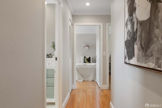 corridor featuring crown molding and light wood-type flooring