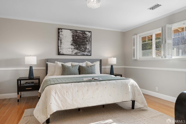 bedroom featuring wood-type flooring and crown molding