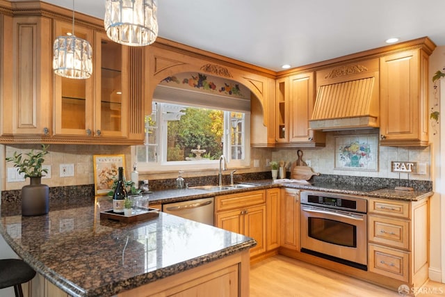 kitchen featuring decorative light fixtures, dark stone countertops, stainless steel appliances, and custom range hood