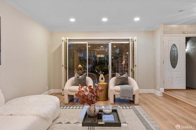 living room with ornamental molding and light hardwood / wood-style flooring