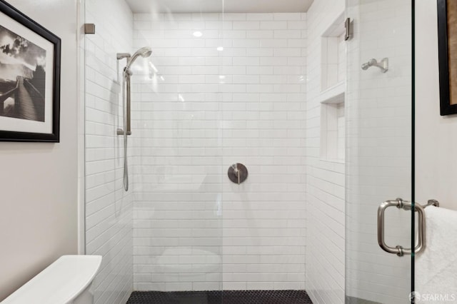 bathroom with a stall shower and toilet