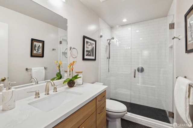 bathroom featuring toilet, a stall shower, recessed lighting, and vanity