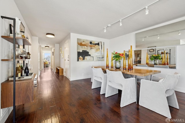 dining space featuring dark wood-style floors and baseboards