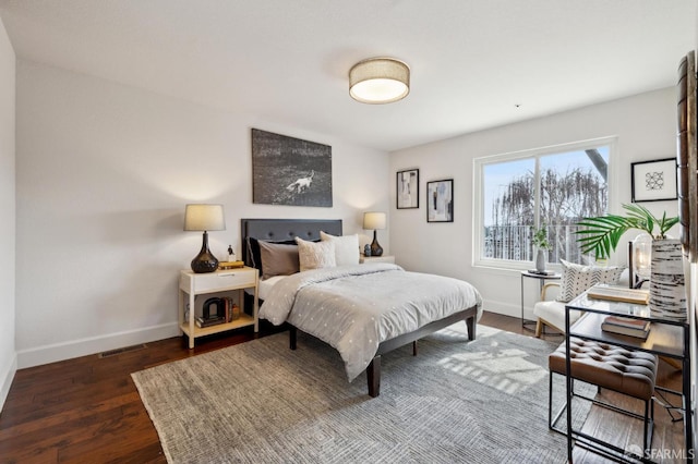 bedroom featuring dark wood finished floors, visible vents, and baseboards