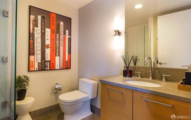 bathroom featuring vanity, a shower with shower door, tile patterned floors, and toilet