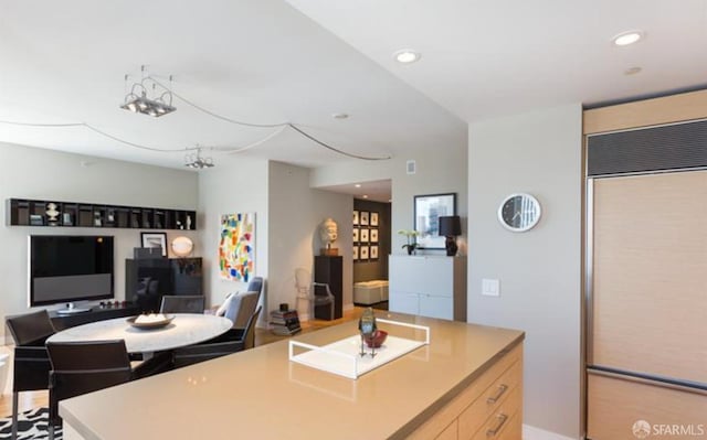 kitchen featuring a kitchen island, paneled fridge, and light brown cabinets