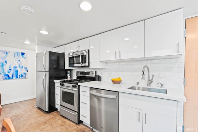 kitchen featuring white cabinets, light tile patterned floors, sink, stainless steel appliances, and decorative backsplash