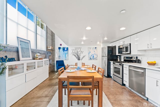 kitchen with decorative backsplash, white cabinets, and appliances with stainless steel finishes