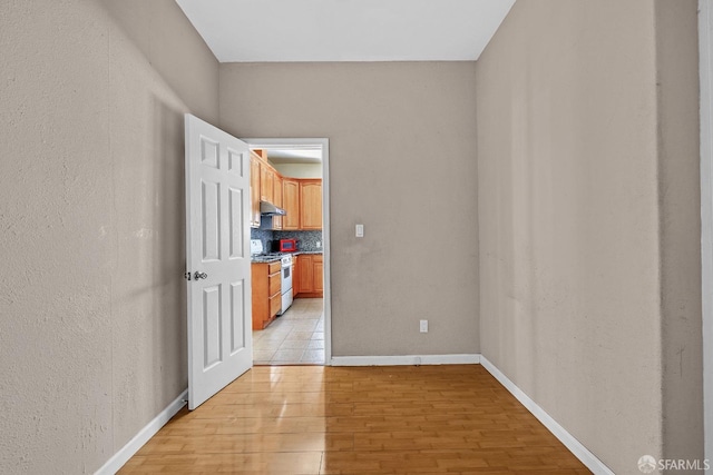 unfurnished room featuring light wood-style flooring and baseboards