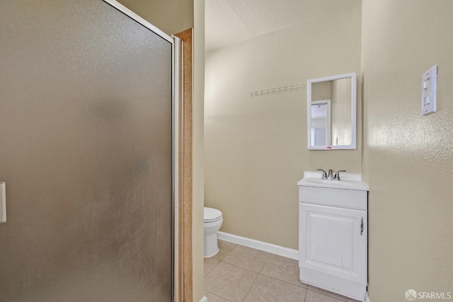 bathroom with tile patterned floors, a shower stall, toilet, vanity, and baseboards