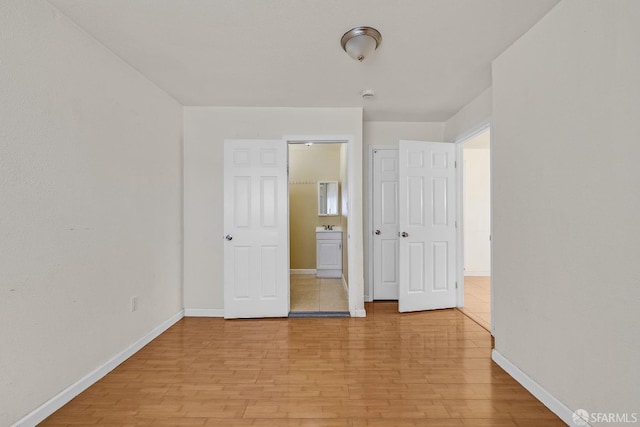 unfurnished bedroom featuring baseboards and light wood-style floors
